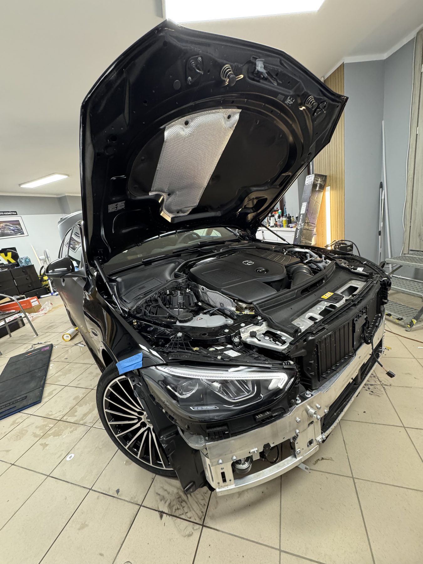 Mercedes z rozebranym frontem podczas przygotowania do oklejania